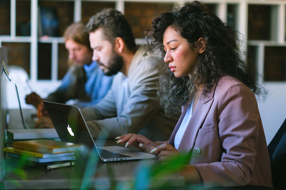Profissionais em ambiente corporativo utilizando notebooks em processo digital seguro